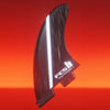 Carbon fiber surf fin with FCS logo on a red background